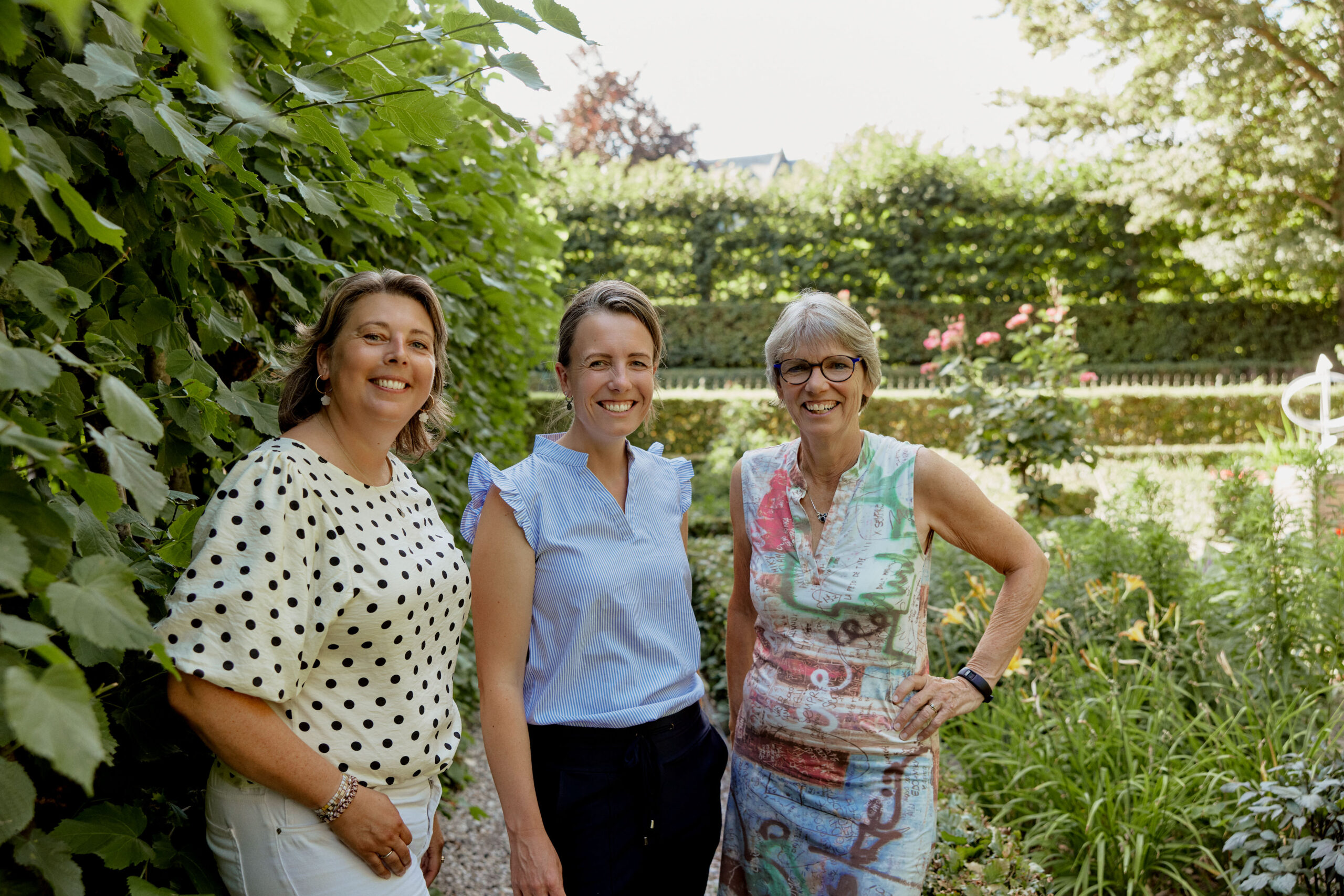 Foto van drie betrokkenen RAP-ZHN, tussen groene bomen en struiken, water op de achtergrond.